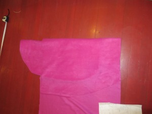Folding lower body of cape on upper body of cape to get symmetrical cut-out for upper cape portion.